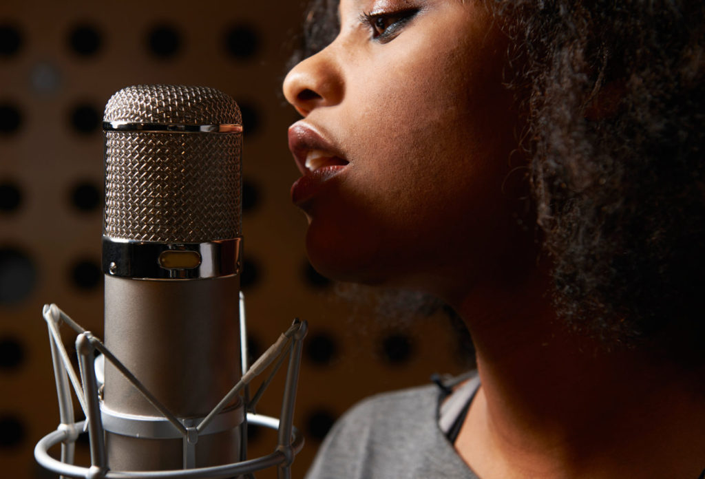 Female voice-over artist In Recording Studio with microphone